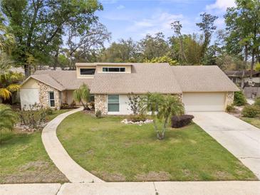 Charming single-story home boasting a stone facade, manicured lawn, and a curved walkway to the front door at 320 Isabella Dr, Longwood, FL 32750