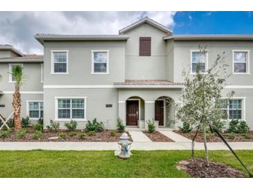 Inviting townhome with a well-maintained lawn and charming architectural details at 4962 Windermere Ave, Kissimmee, FL 34746