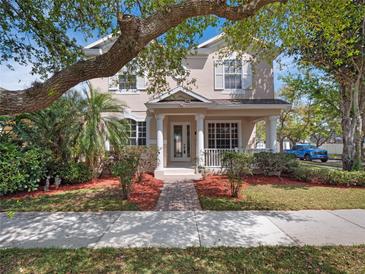 Charming two-story home features a well-manicured lawn, inviting front porch, and elegant architectural details at 6475 New Independence Pkwy, Winter Garden, FL 34787