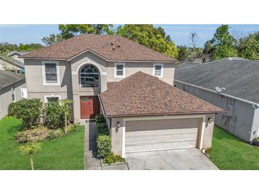 Charming two-story home with a well-manicured lawn and attached two car garage at 122 Carmel Bay Dr, Sanford, FL 32771