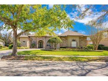 Charming home featuring stone accents, a well-manicured lawn, and mature trees offering curb appeal at 1649 Kersley Cir, Lake Mary, FL 32746