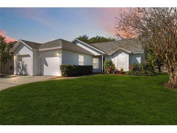 Charming single-story home with a well-manicured lawn, lush landscaping, and an attached two-car garage at 5600 Revelwood Loop, Winter Park, FL 32792