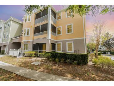 Beautiful three-story condo with yellow siding, white trim, and screened in patios at 6412 Queens Borough Ave # 215, Orlando, FL 32835