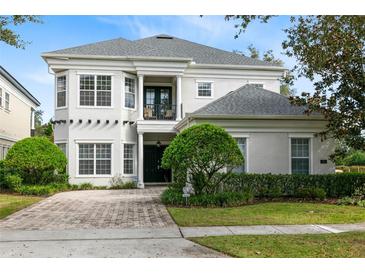 Beautiful two-story home with a well-maintained lawn, manicured shrubs, and a brick driveway at 7419 Gathering Ct, Reunion, FL 34747