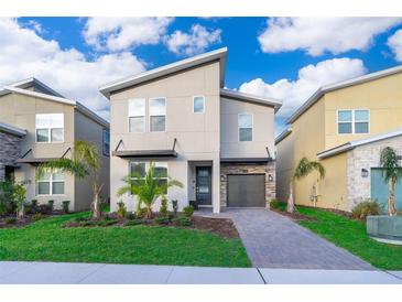 Modern two-story home featuring a stylish design, a paved driveway, and well-manicured landscaping at 830 Sticks, Davenport, FL 33896