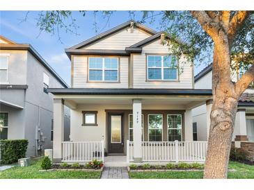 Charming two-story home with a welcoming front porch and manicured lawn in a modern neighborhood at 9149 Grand Island Way, Winter Garden, FL 34787