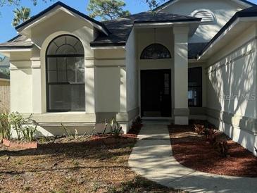 Charming home's front entrance features arched windows, a walkway, and a well-maintained exterior at 1059 Manigan Ave, Oviedo, FL 32765