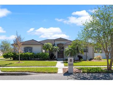 Stunning single-story home with tile roof, manicured lawn, and beautiful tropical landscaping at 1601 Carillon Park Dr, Oviedo, FL 32765