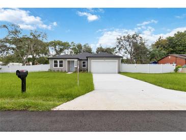 Charming single-story home with a well-manicured lawn and a two-car garage at 2341 Oleander Rd, Deland, FL 32724