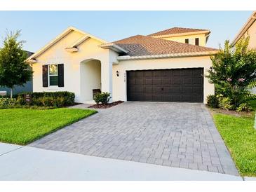 Charming single-Gathering home featuring a paved driveway, a two-car garage, and well-maintained landscaping at 4418 Lions Gate Ave, Clermont, FL 34711