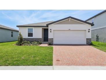 Charming home featuring a brick driveway, two-car garage, and manicured lawn at 4550 Windy Oak Way, St Cloud, FL 34772
