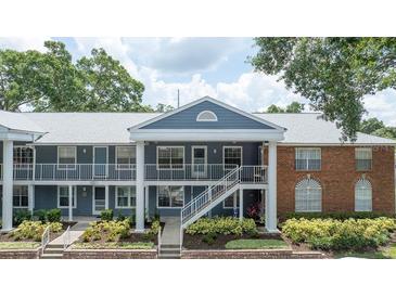 Inviting two-story condo featuring a charming brick accent, landscaped front and private outdoor balcony at 5417 Lake Margaret Dr # 39, Orlando, FL 32812
