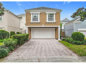 Inviting home featuring an attached two-car garage and a brick paver driveway at 7407 Excitement Dr, Reunion, FL 34747