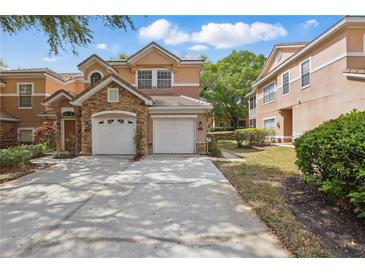 Charming two-story townhome with stone accents, two-car garage, and spacious driveway at 7620 Bay Port Rd # 39, Orlando, FL 32819