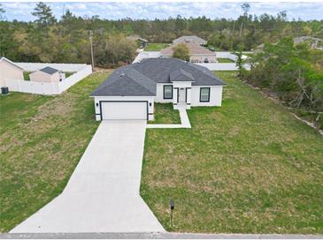 New construction featuring a well-manicured lawn and concrete driveway leading to an attached two-car garage at 16121 Sw 37Th Terrace Rd, Ocala, FL 34473