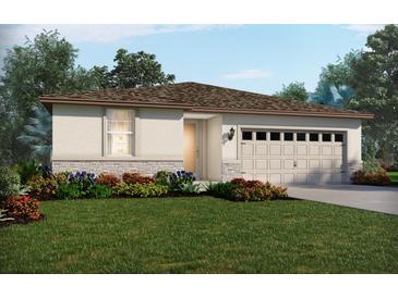 Inviting single-story home with a two-car garage, stone accents, and beautifully landscaped front yard at 305 Castle Dr, Lake Alfred, FL 33850