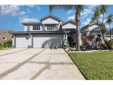 Inviting two-story home with a well-manicured lawn and a three-car garage at 3244 Amaca Cir, Orlando, FL 32837