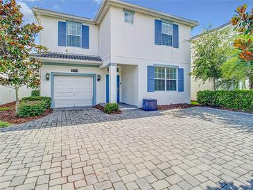 Charming two-story home with blue shutters and a brick driveway at 4704 Sleepy Hollow Dr, Kissimmee, FL 34746