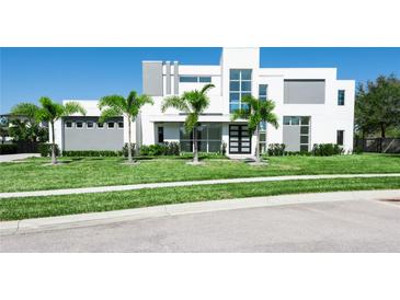 Modern two-story home featuring a geometric design, tall windows, and meticulously maintained landscaping with palm trees at 6106 Marleon Dr, Windermere, FL 34786