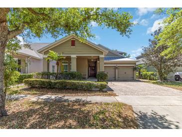 Charming single-story home with a brick driveway, a well-manicured lawn, and a two-car garage at 6799 Helmsley Cir, Windermere, FL 34786