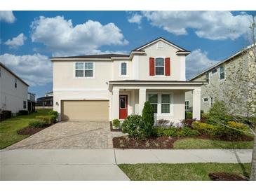 Charming two-story home featuring a two-car garage and a beautifully landscaped front yard at 1720 Sawyer Palm Pl, Kissimmee, FL 34747