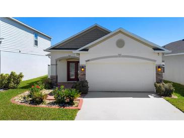 Charming single-story home showcasing a well-manicured lawn and an attached two-car garage at 2285 Canyon Breeze Ave, Kissimmee, FL 34746