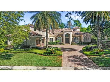 Stunning home featuring mature landscaping, a tile roof, an arched entryway, and a circular driveway at 25603 High Hampton Cir, Sorrento, FL 32776