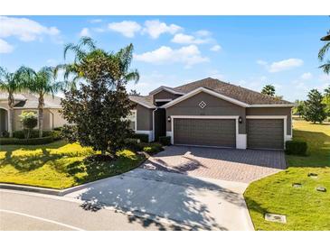 Beautiful home featuring a three-car garage, well-maintained lawn, and mature landscaping at 3492 La Jolla Dr, Clermont, FL 34711