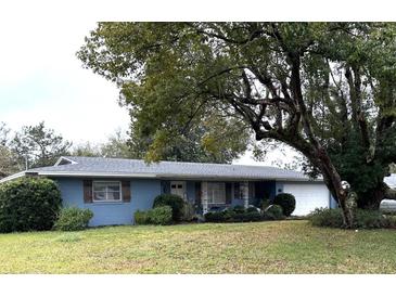 Charming single-story home with blue siding, shutters, and a well-manicured lawn at 63 Dahlia Dr, Debary, FL 32713