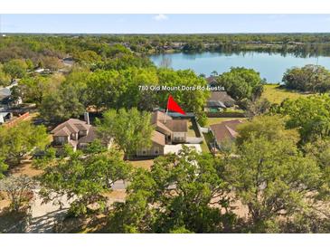 An aerial view of a single Gathering home, surrounded by mature trees and a large lake in the background at 780 Old Mount Dora Rd, Eustis, FL 32726