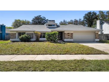 Charming single-story home featuring a well-maintained lawn, brick accents, and an attached two-car garage at 822 Swaying Palm Dr, Apopka, FL 32712