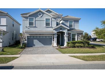 Beautiful two-story home featuring a paved driveway, a two-car garage, and well-maintained landscaping at 9033 Hazard St, Davenport, FL 33896