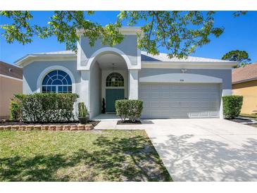 Charming single-story home showcasing a well-manicured lawn and a welcoming arched entryway at 908 Jade Forest Ave, Orlando, FL 32828