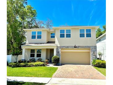 Charming two-story home features a brick driveway, manicured lawn, and stone accents for an elegant curb appeal at 1337 Ash Tree Cv, Casselberry, FL 32707