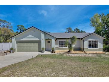 Charming single-story home featuring a well-manicured lawn, attached garage, and inviting front entrance at 209 Roman Ct, Deltona, FL 32738