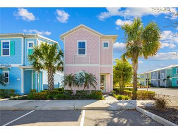 Charming pastel-colored two-story home with tropical landscaping and palm trees in a vibrant community at 2967 Latitude Ln, Kissimmee, FL 34747