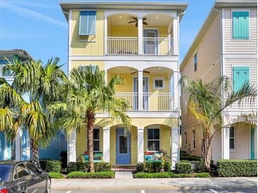 Charming two-story home with balconies, yellow siding, and lush landscaping, perfect for coastal living at 3083 Pirate Way, Kissimmee, FL 34747