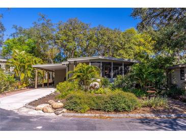Charming home featuring a carport, mature landscaping, and a screened-in porch for outdoor living at 410 N Niblick Ln, Lake Mary, FL 32746