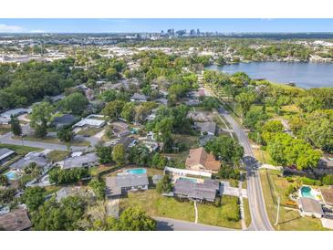 Spacious neighborhood with mature trees, a lake, and a view of the city skyline in the distance at 533 Baxter St, Orlando, FL 32806