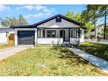 Charming single Gathering home showcasing a well-manicured lawn, garage, and cozy front porch at 819 State Ave, Daytona Beach, FL 32117