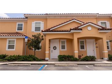 Inviting exterior of a two-story townhome with a red tile roof and a well-manicured front yard at 2653 Roadster Ln, Kissimmee, FL 34746