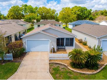 Charming single-story home with a well-manicured lawn, white picket fence, and attached one car garage at 790 Blake Ln, The Villages, FL 32162