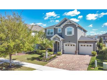 Charming two-story home with a paved driveway, lush landscaping, and a two-car garage at 8549 Lovett Ave, Orlando, FL 32832