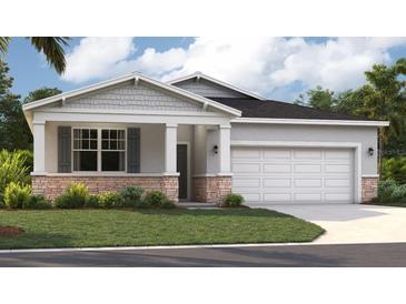 Charming single-story home featuring a stone-accented facade, well-manicured lawn, and an attached two-car garage at 917 Pearlwood Loop, Eagle Lake, FL 33839