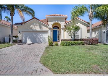 Charming single-story home featuring a terracotta roof, blue door, and well-maintained landscaping at 1019 Tuscan Hills Blvd, Davenport, FL 33897