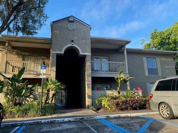 A well-maintained building with stucco exterior and beautiful landscaping and balcony on a sunny day at 395 Wymore Rd # 200, Altamonte Springs, FL 32714