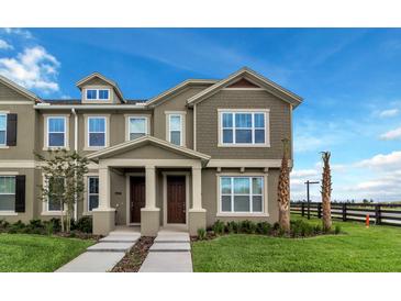 Inviting townhome with a two-story facade, manicured lawn, and charming front porch at 6633 Calamondin Dr, Winter Garden, FL 34787