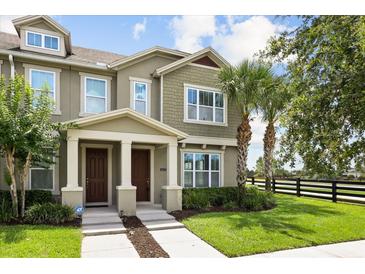 Charming home exterior featuring a well-maintained lawn, inviting entryway, and beautiful palm trees at 6633 Calamondin Dr, Winter Garden, FL 34787
