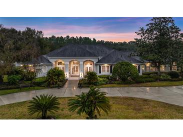 Elegant home featuring lush landscaping, symmetrical design, and a welcoming entrance at twilight at 1080 Edmiston Pl, Longwood, FL 32779