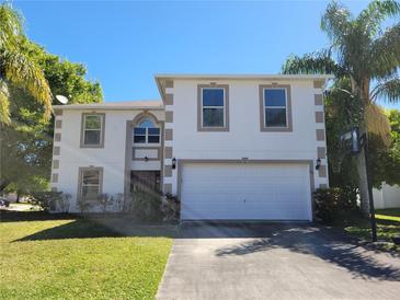 Inviting two-story home featuring an attached two-car garage and well-maintained lawn at 115 Royalty Cir, Sanford, FL 32771